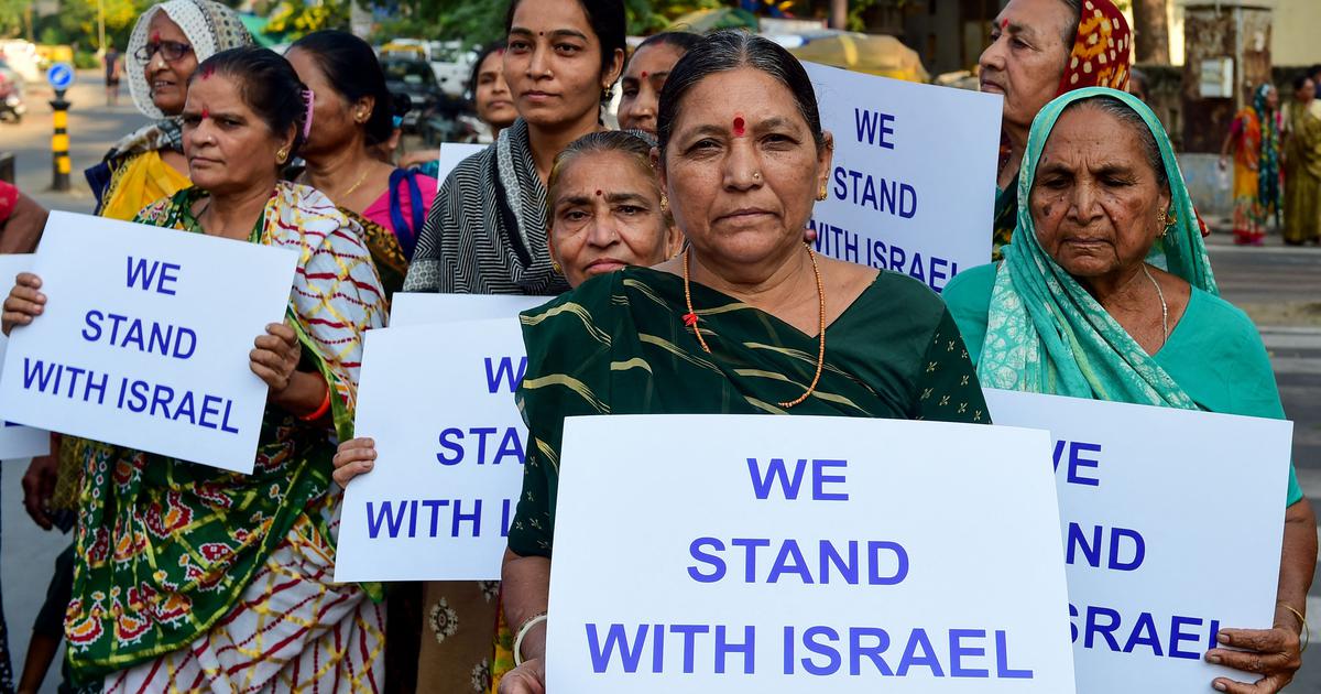 Women in India holding signs that read We Stand With Israel
