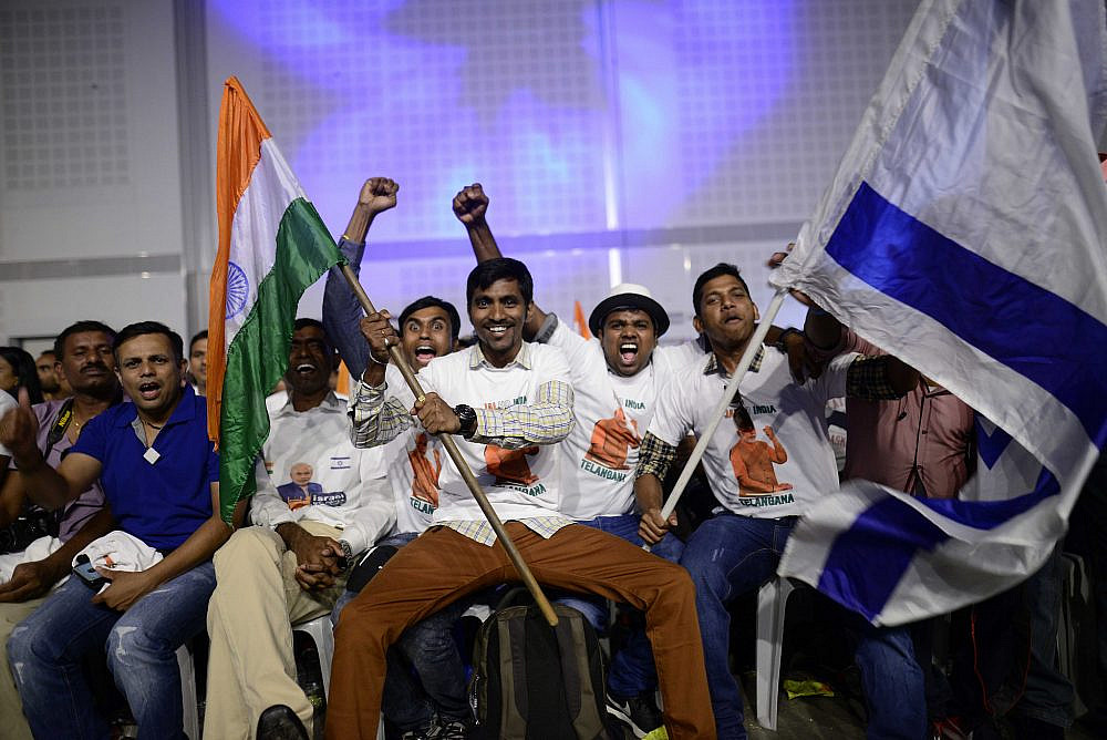 People waving Indian and Israeli flags at a public gathering